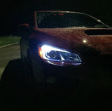 Passenger-side view of Subaru WRX with bright LED C-lights in a dark setting.