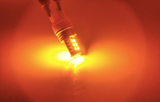7443 LED bulb emitting a vibrant amber beam for turn signal visibility.