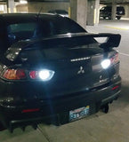 Mitsubishi Evo X reverse lights with high-powered white LED bulbs lit in parking garage.